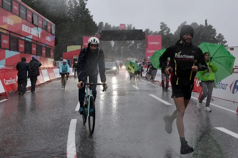 Persone si allontanano dopo che una forte grandinata ha colpito la zona dell'arrivo della terza tappa della Vuelta a Espana 2026, una corsa di 174 km tra Gruissan e Font-Romeu il 24 agosto 2026